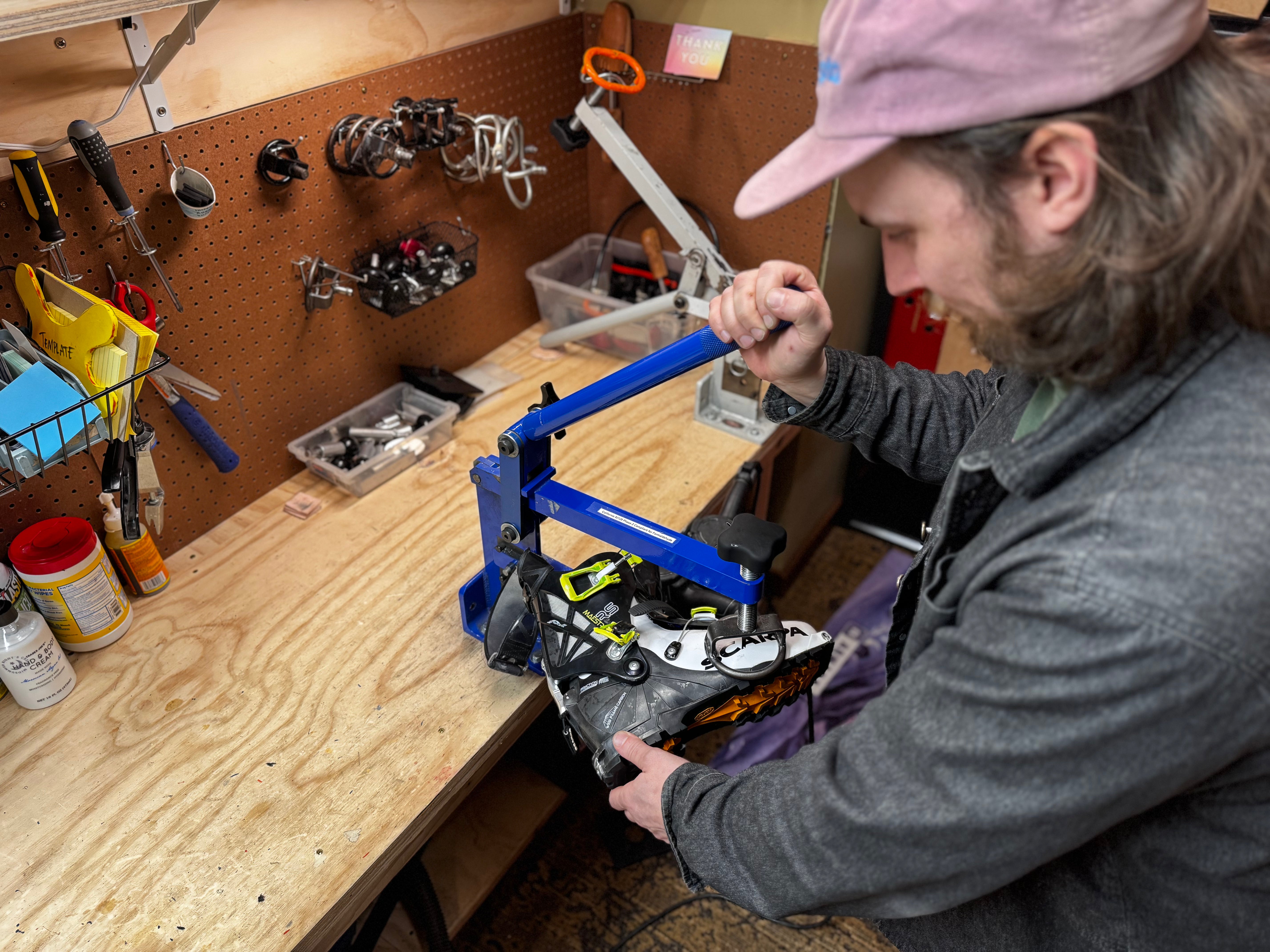 Person working on a project at a workshop bench with tools and equipment.